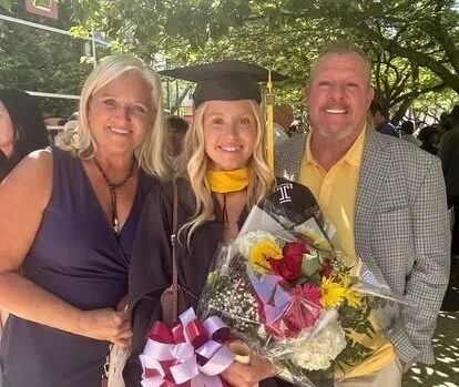 Graduate wearing cap and gown with proud parents