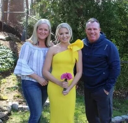 Young woman in yellow gown holding bouquet