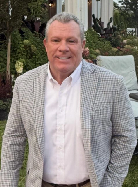 Smiling man in checked blazer outdoors