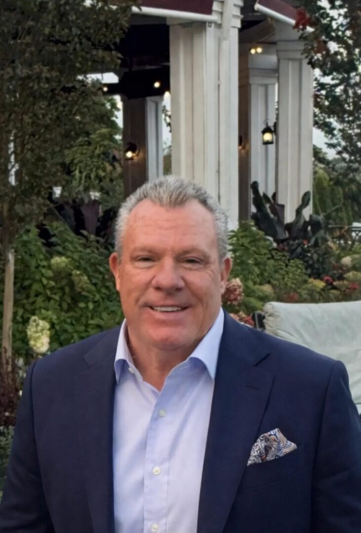 Smiling man in navy suit with pocket square