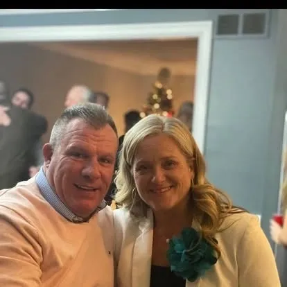 Smiling couple posing indoors with holiday tree