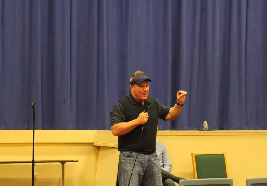 Man in cap speaking on stage