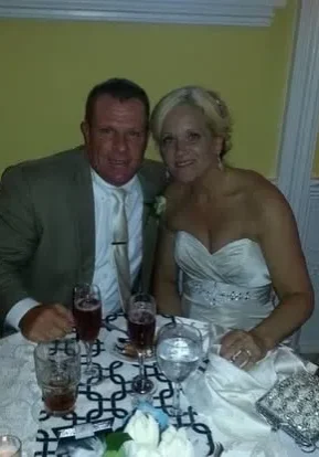 Bride and groom smiling at reception table