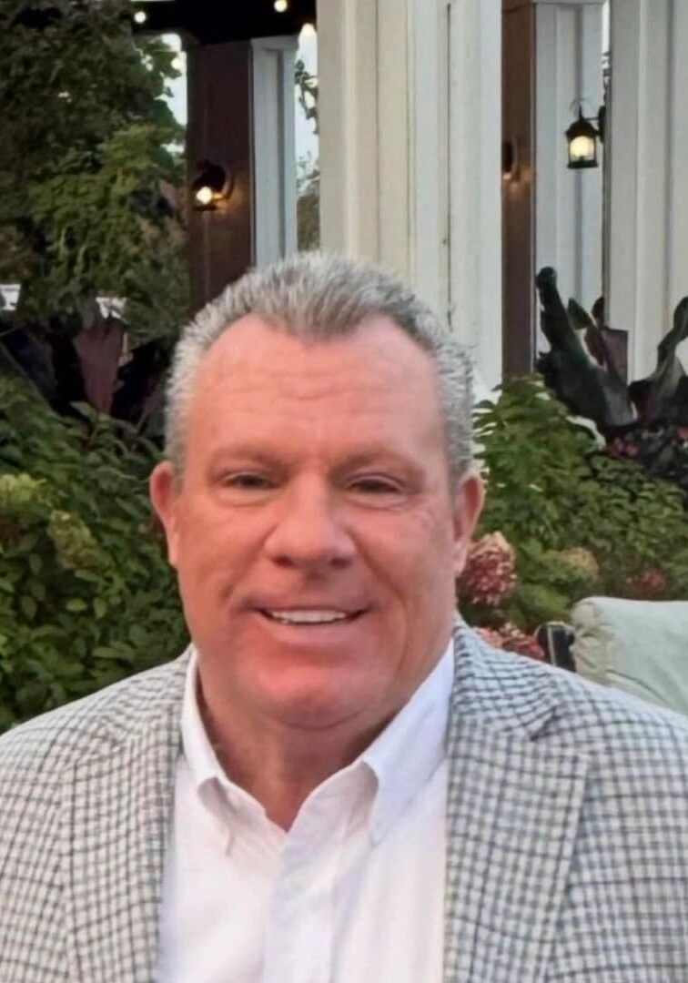 Smiling man in checked blazer outdoors