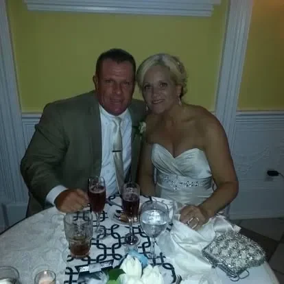 Smiling newlyweds seated at decorated wedding table