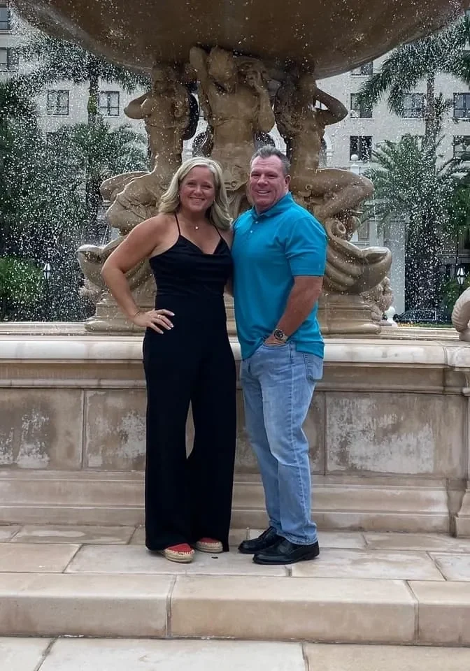 Man and woman posing by ornate fountain