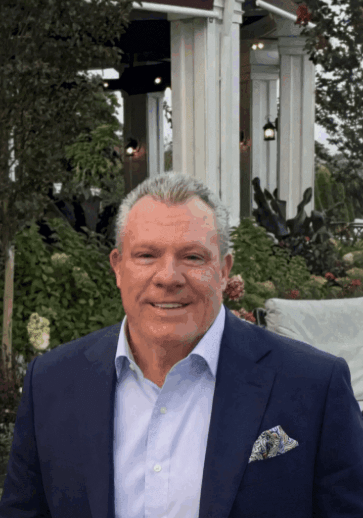 Smiling man in navy suit at garden event