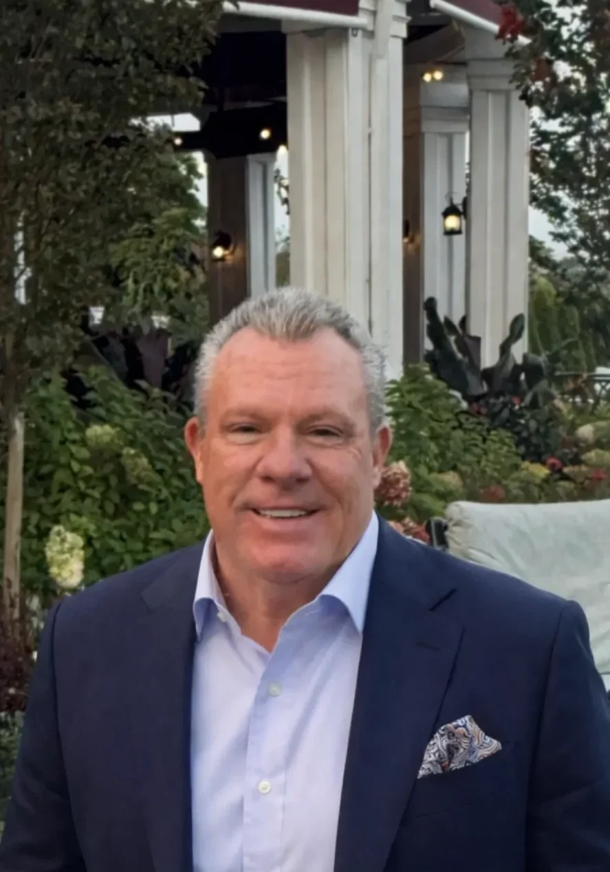 Smiling man in navy suit outdoors