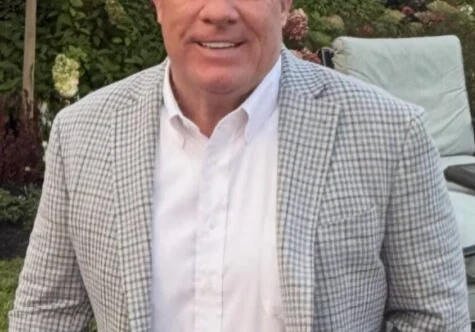 Smiling man in checked blazer outdoors