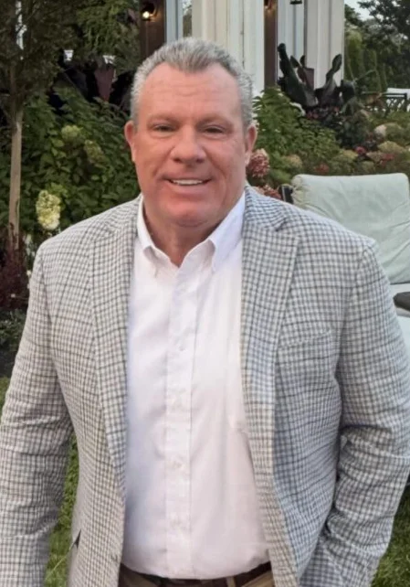 Smiling man in checked blazer outdoors